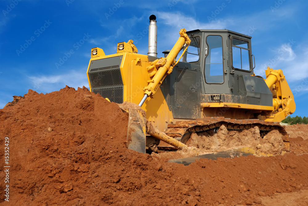 Close view of heavy bulldozer moving sand in sandpit