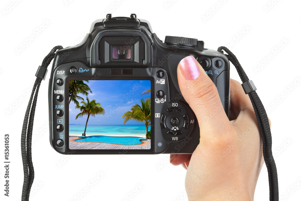 Camera in hand and beach landscape Camera in hand and beach landscape