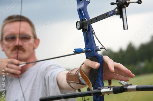 man shooting to archery target.