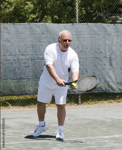 middle age tennis player  serve ball on club tennis court © robert lerich