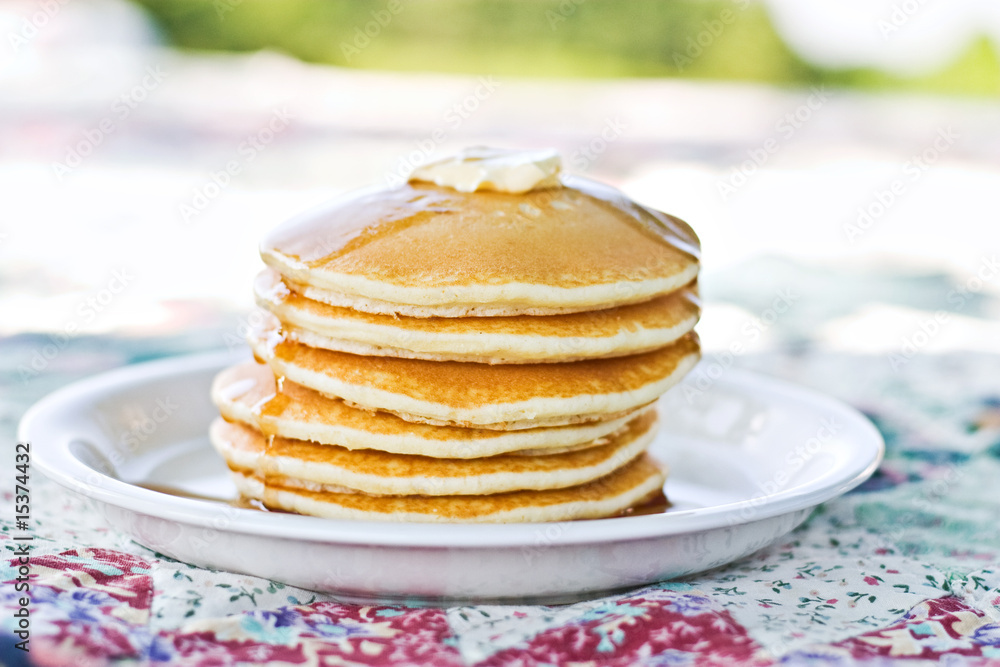 Stack of pancakes with syrup served outdoors. Stack of pancakes with syrup served outdoors.