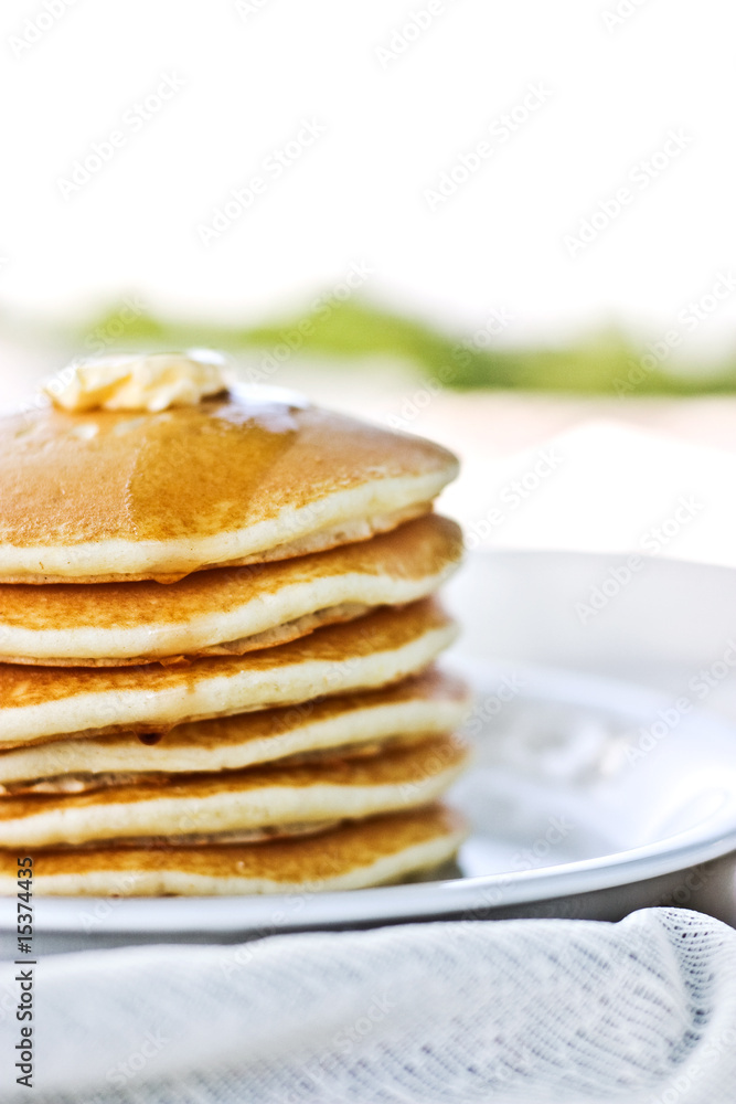 Stack of pancakes with syrup served outdoors. Stack of pancakes with syrup served outdoors.