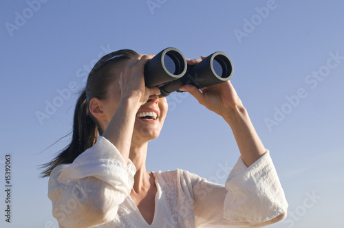 Frau mit Fernglas lacht