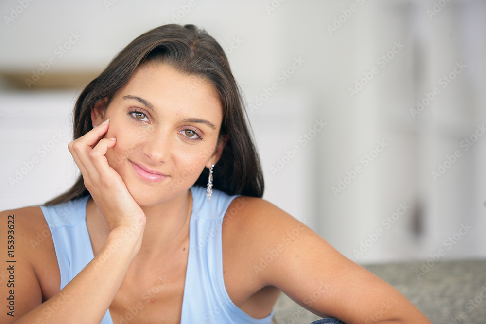 Portrait d'une femme souriante assise sur un canapé Portrait d'une femme souriante assise sur un canapé