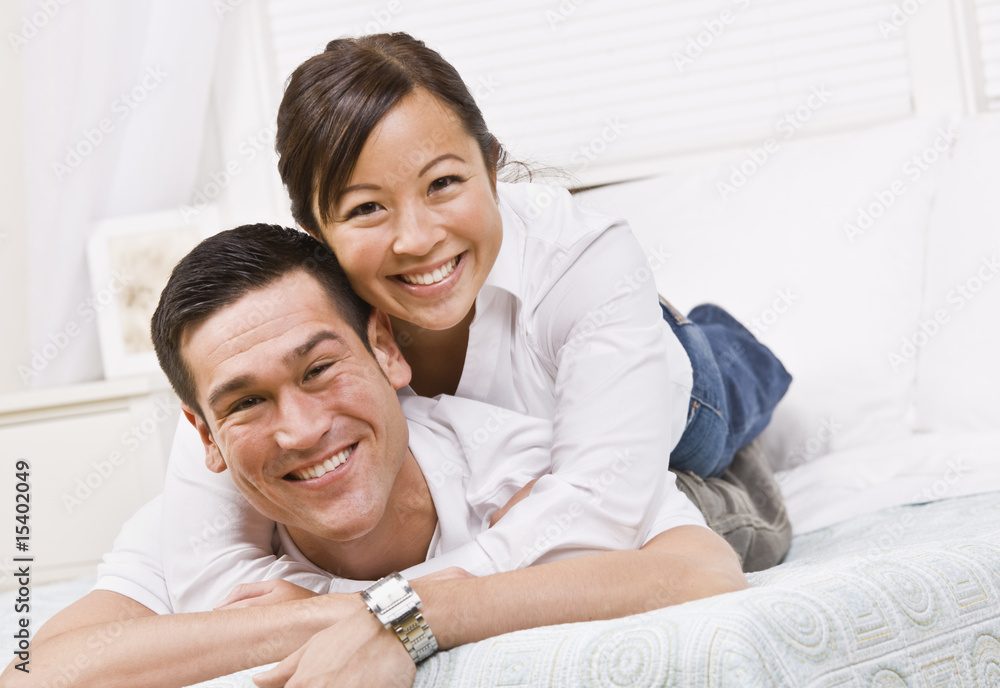 Happy Couple Posing on a Bed Happy Couple Posing on a Bed