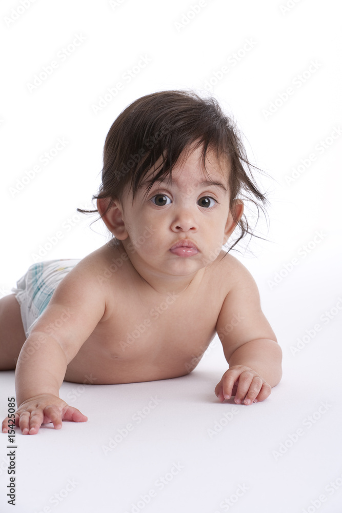 Baby girl lying on her belly on white background Baby girl lying on her belly on white background