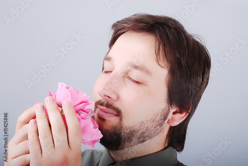 Cute man smeling pink roses photo