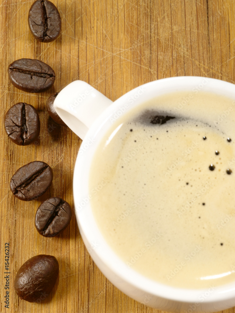 cup of espresso with beans on the wooden desk cup of espresso with beans on the wooden desk