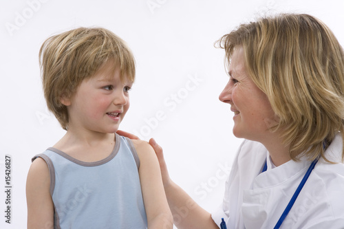 Female doctor is talking to a little boy