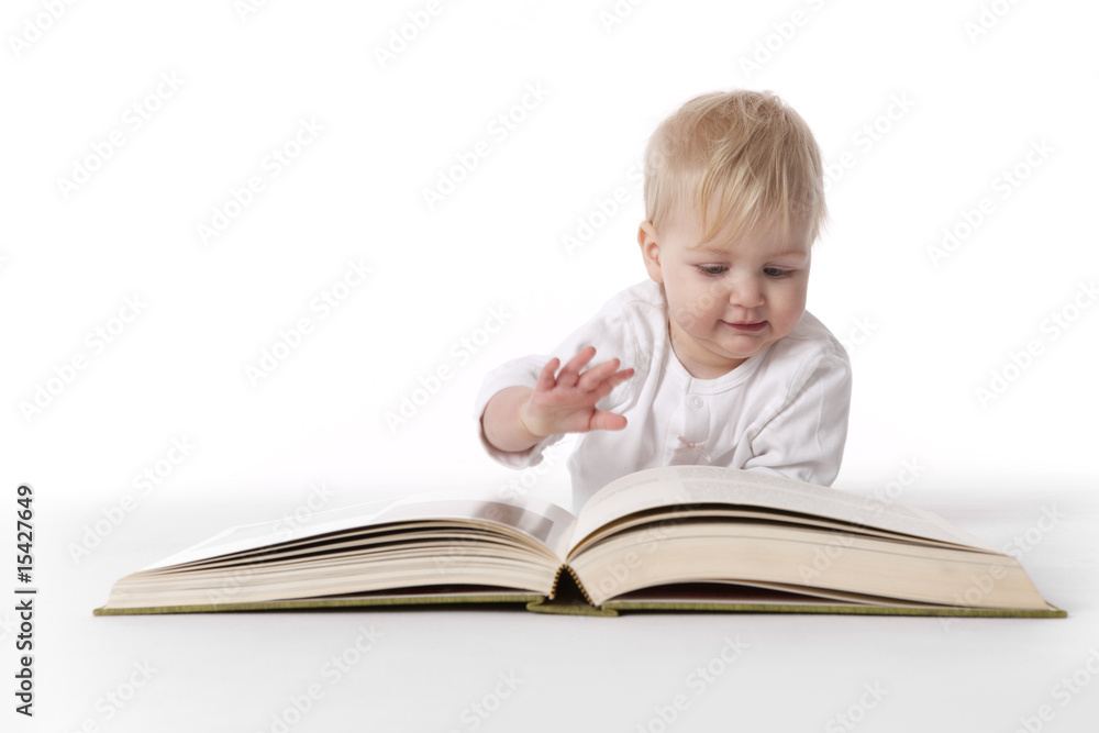 Toddler girl is reading a large book Toddler girl is reading a large book