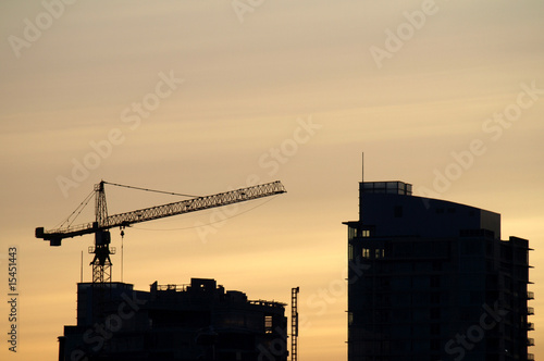 Construction crane building a high rise at dusk