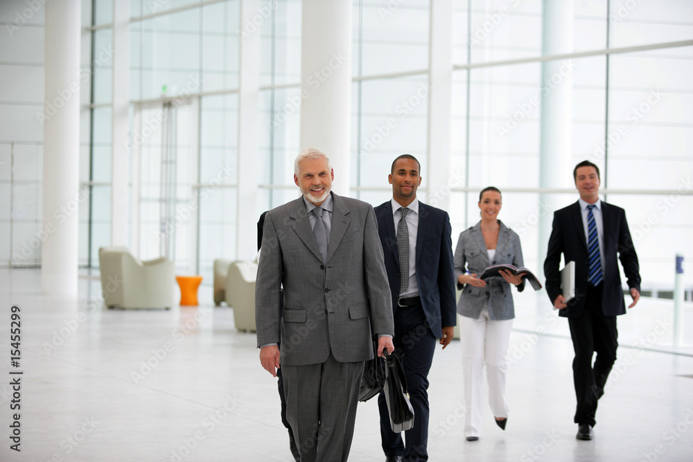 Hommes et femmes d'affaires marchant dans une société moderne Hommes et femmes d'affaires marchant dans une société moderne