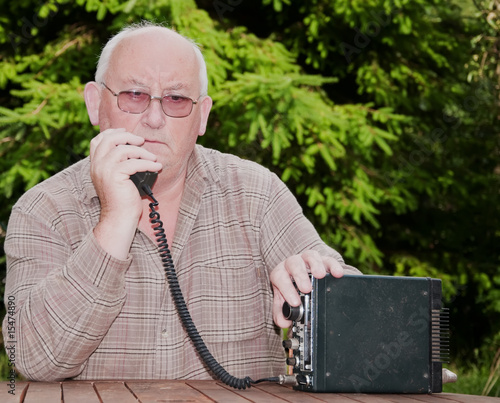 closeup image of senior making amateur radio 2way call photo