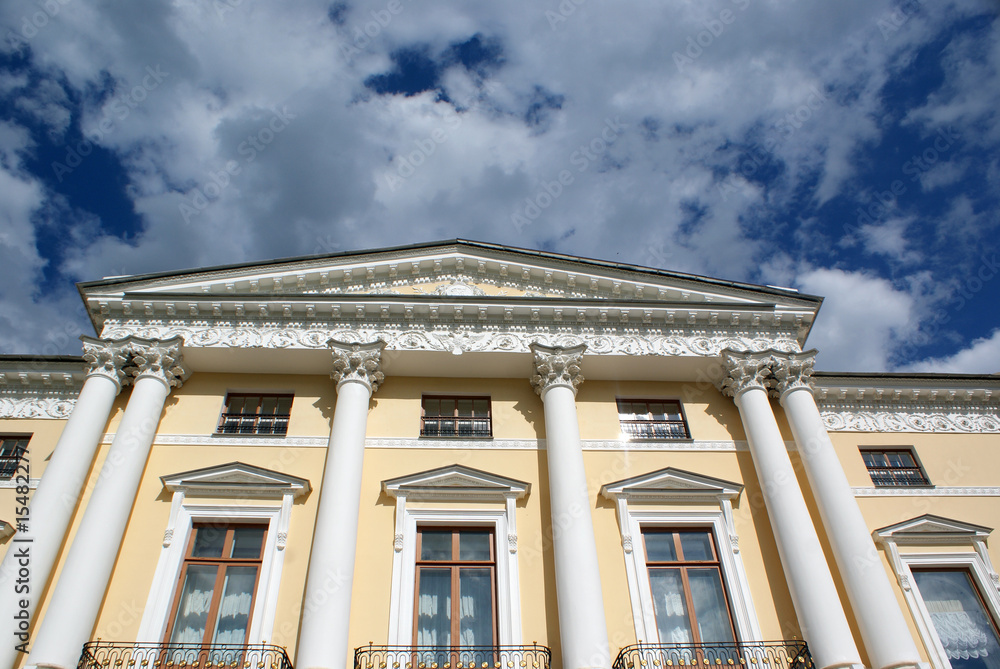 The ancient house against the blue sky with clouds The ancient house against the blue sky with clouds