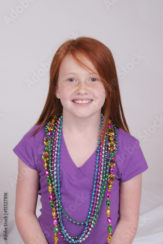 Cute redhead girl with beads smiling at the camera photo