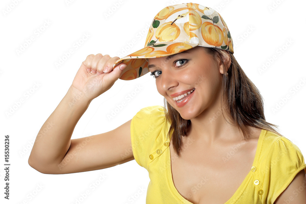 woman in yellow shirt with hands near peak of a peach cap woman in yellow shirt with hands near peak of a peach cap