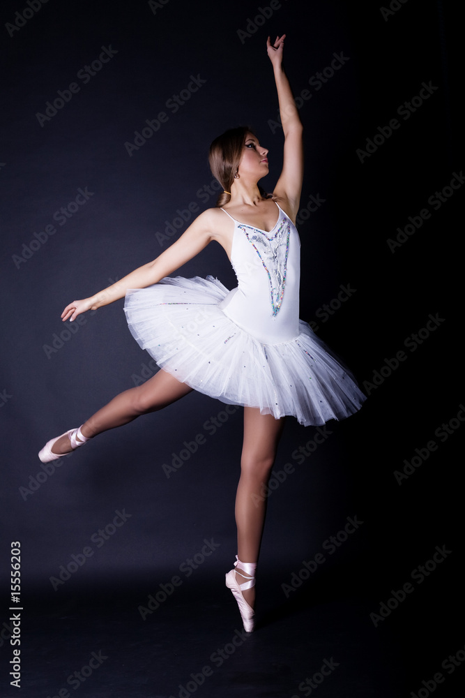 Ballerina in white tutu on black background