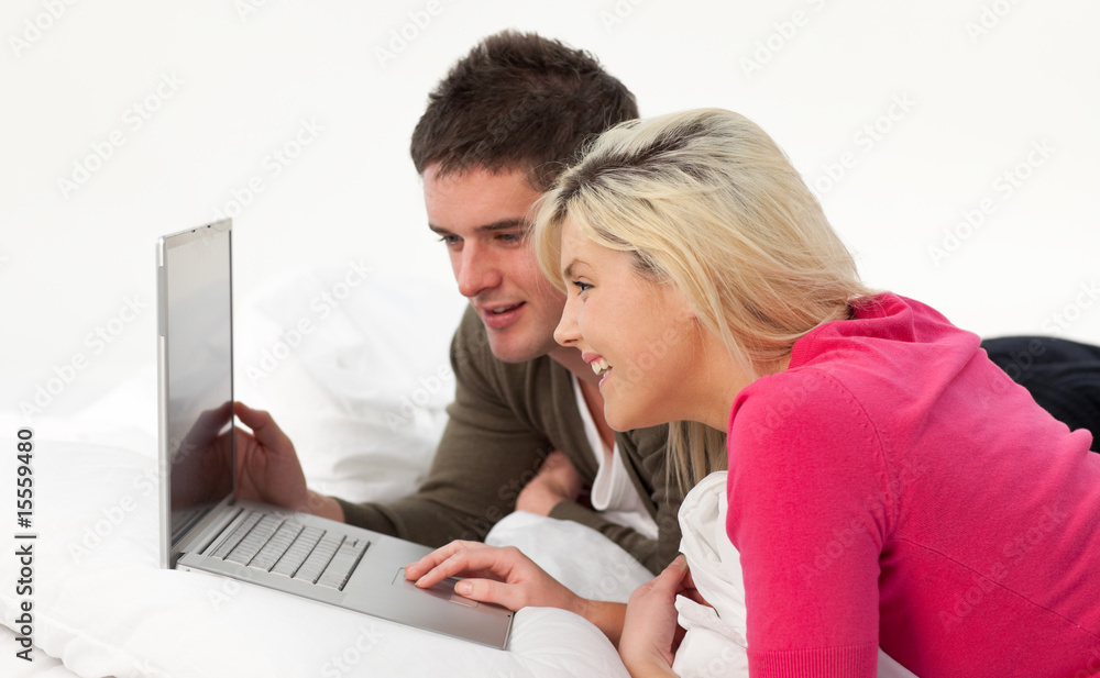 Boy and girl using a latop in bed Boy and girl using a latop in bed