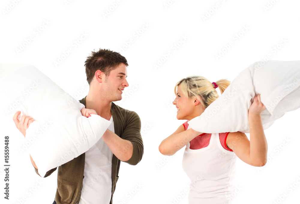 Young girl and boy having a pillow fight Young girl and boy having a pillow fight