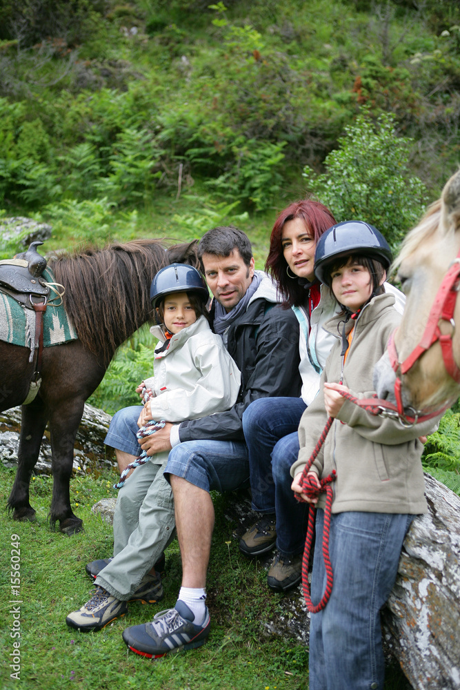 Couple souriants avec enfants à la campagne avec poneys
