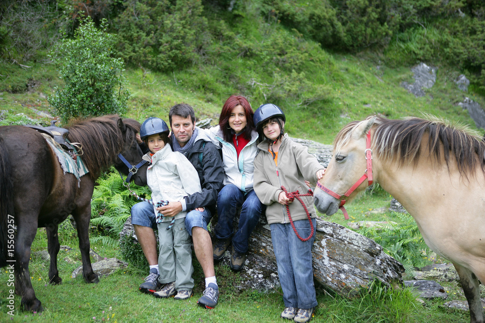 Couple souriants avec enfants à la campagne avec poneys Couple souriants avec enfants à la campagne avec poneys