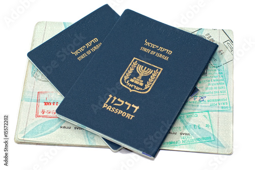Israeli passports sitting on an open passport with stamps
