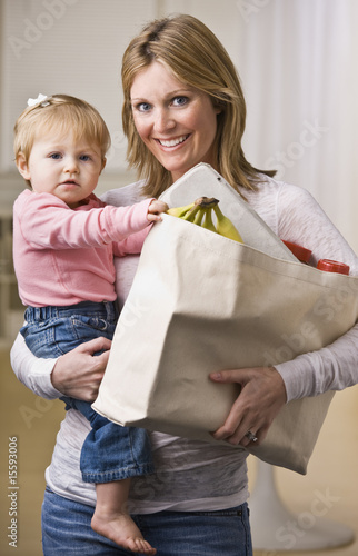 Mother Holding Daughter and Groceries
