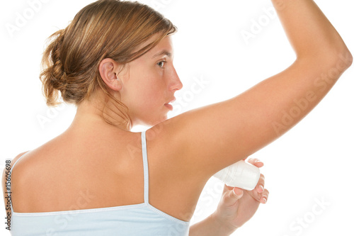 Portrait of young woman using deodorant