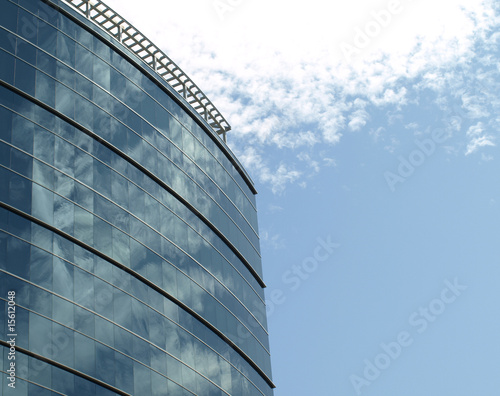 Glass windows in a business building reflecting the sky.