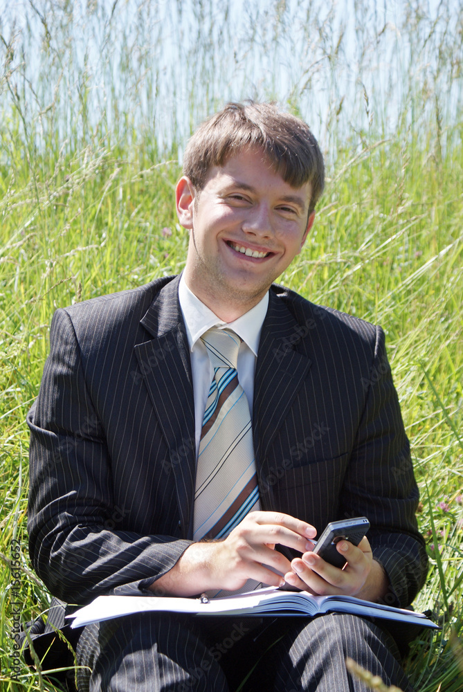 Smiling businessman working outdoor on his PDA Smiling businessman working outdoor on his PDA