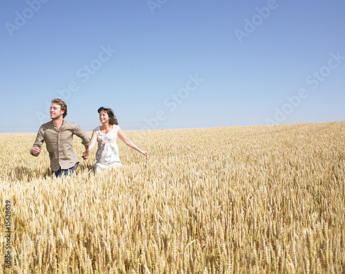 couple running in wheat field