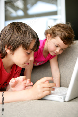 Enfants sur un canapé devant un ordinateur portable