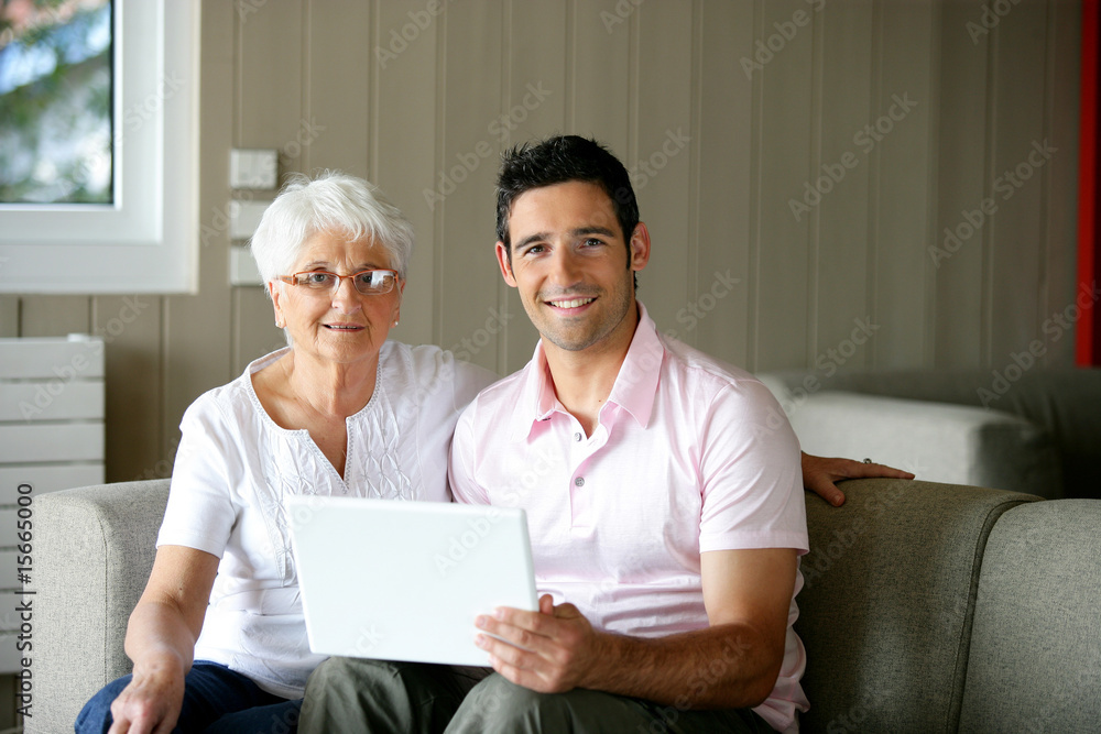 homme et femme senior souriants devant un ordinateur portable