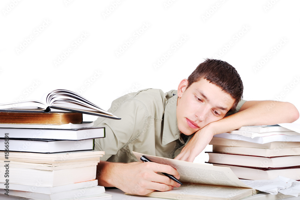 Young man with many books siting and writing Young man with many books siting and writing