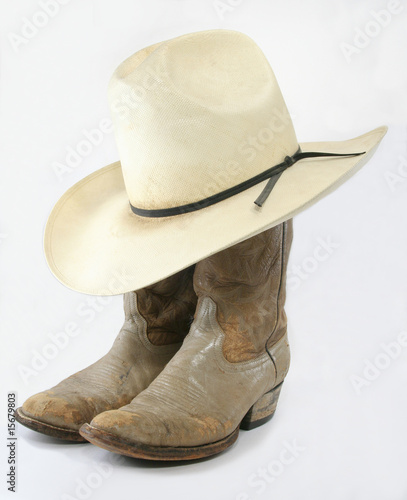Worn cowboy boots with straw hat