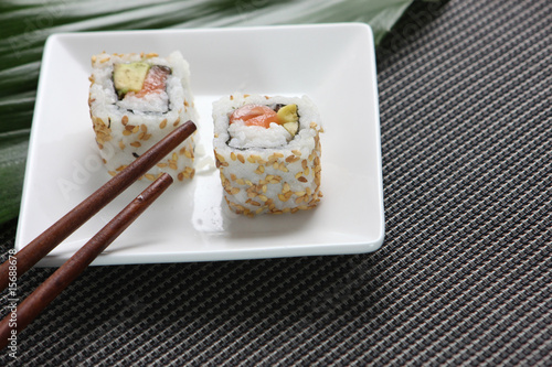 Sushis dans une petite assiette avec baguettes asiatiques photo