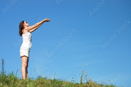 woman in field under blue sky