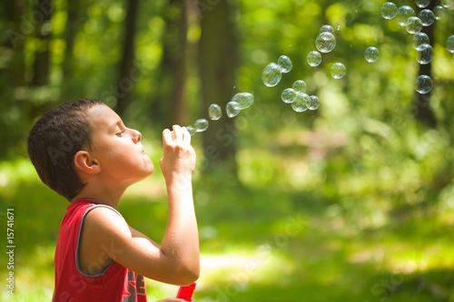 Cute kid blowing soap bubbles