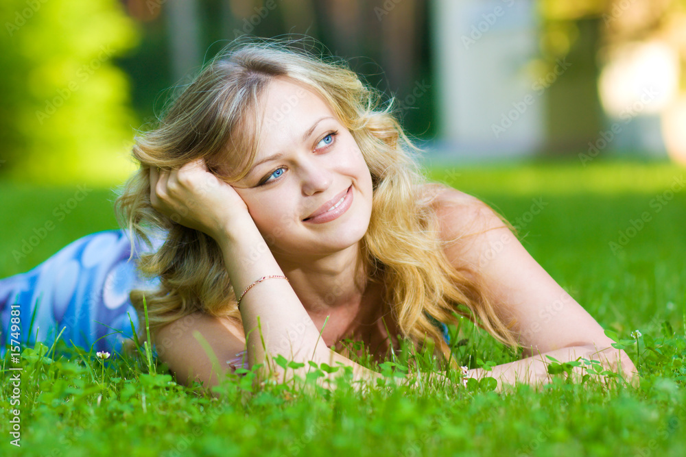 Young woman lying on a green grass Young woman lying on a green grass