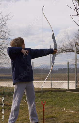 Teenage boy archer practicing in the back-yard.