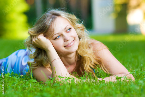 Young woman lying on a green grass
