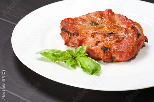 Grilled pork chop on a white plate