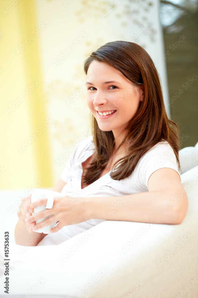 Junge Frau Zuhause mit Kaffeetasse lachend Junge Frau Zuhause mit Kaffeetasse lachend