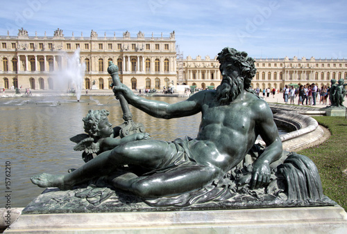 Statue d'un homme sur fond de château de Versailles