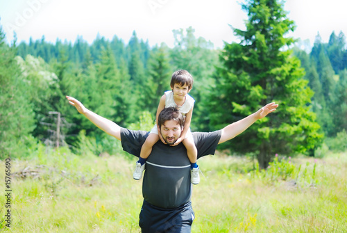 Happy father and son flying in forest