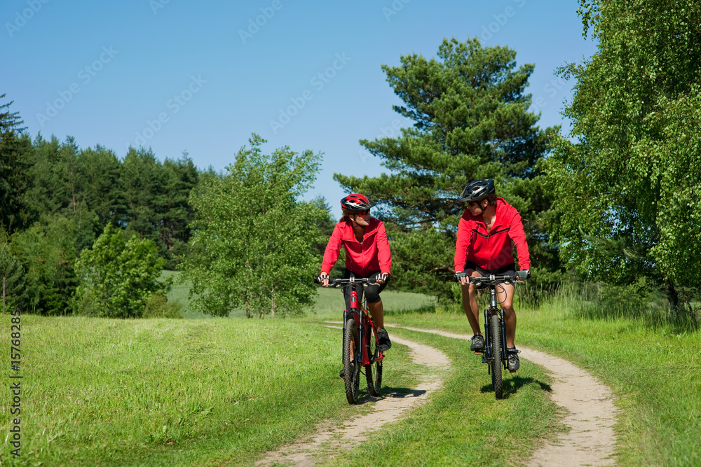 Young man and woman cycling in a nature