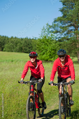 Young man and woman cycling in the nature