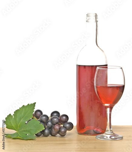 Bottle, goblet  and grapevine on table
