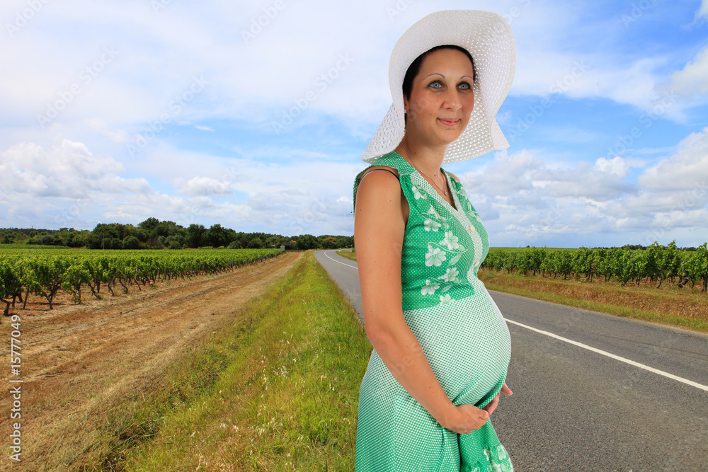 Jeune femme enceinte au bord d'une route