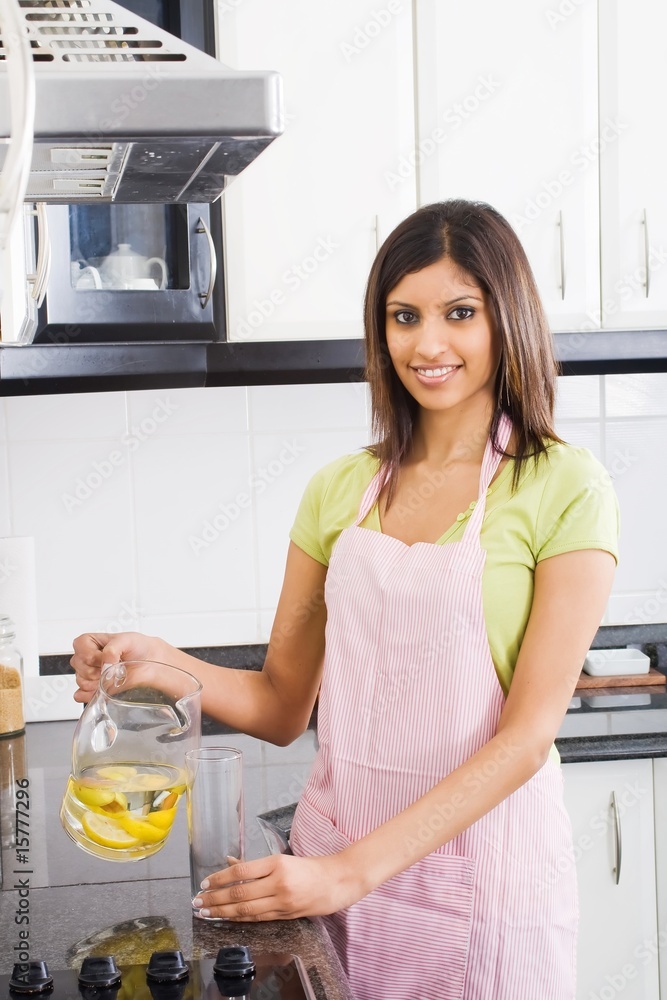 woman pouring drinks in kitchen